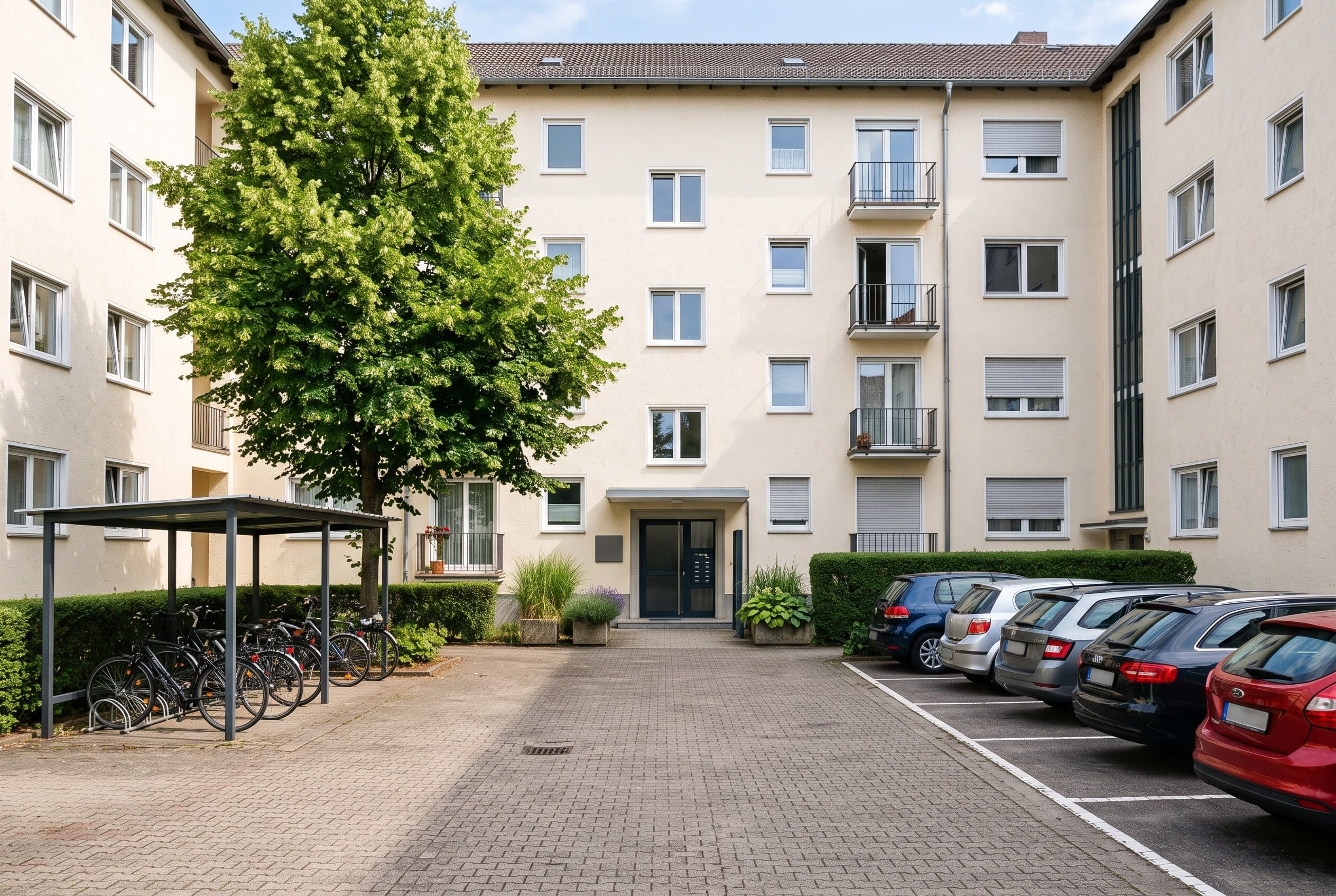 Der Hof hinter dem Haus mit dem stufenlosen Eingang, dem Fahrradstellplatz und den Parkplätzen